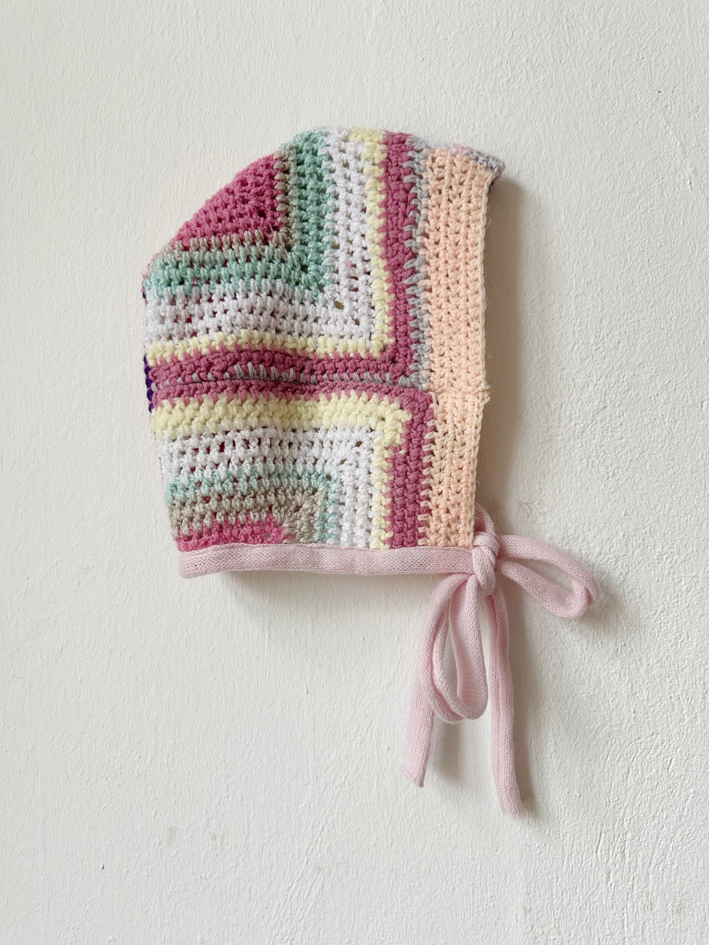 Detail view of pastel coloured crocheted bonnet.