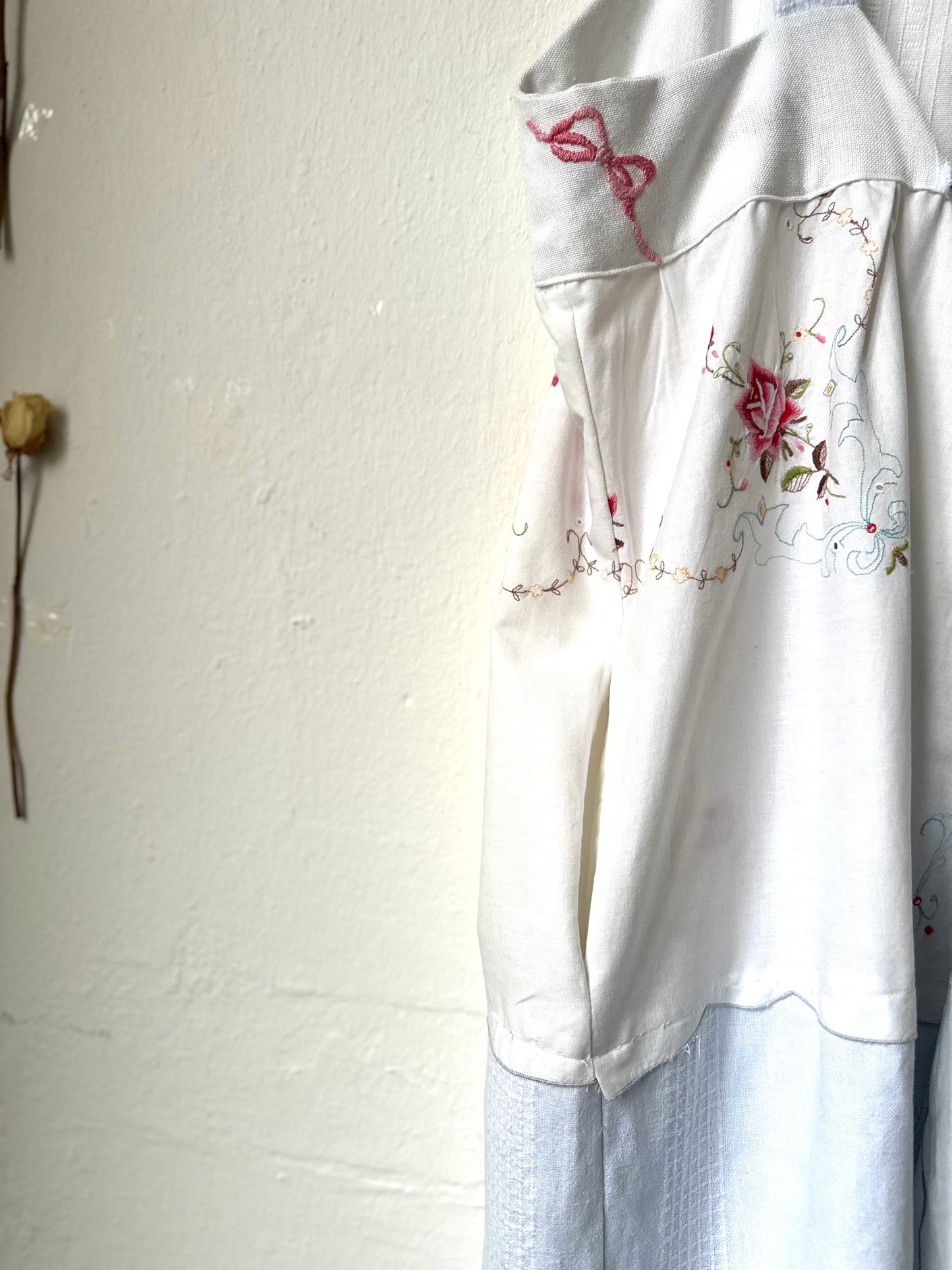 A detail view of the side pocket in the skirt of a blue and white dress