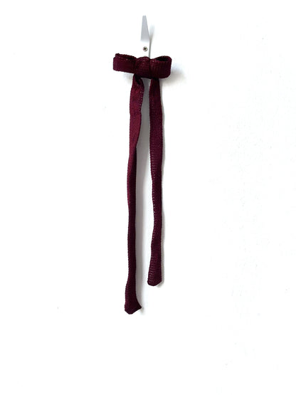 Burgundy bow hair clip on a white background