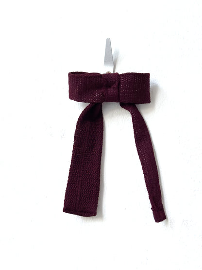 Burgundy knitted bow tie on a white background