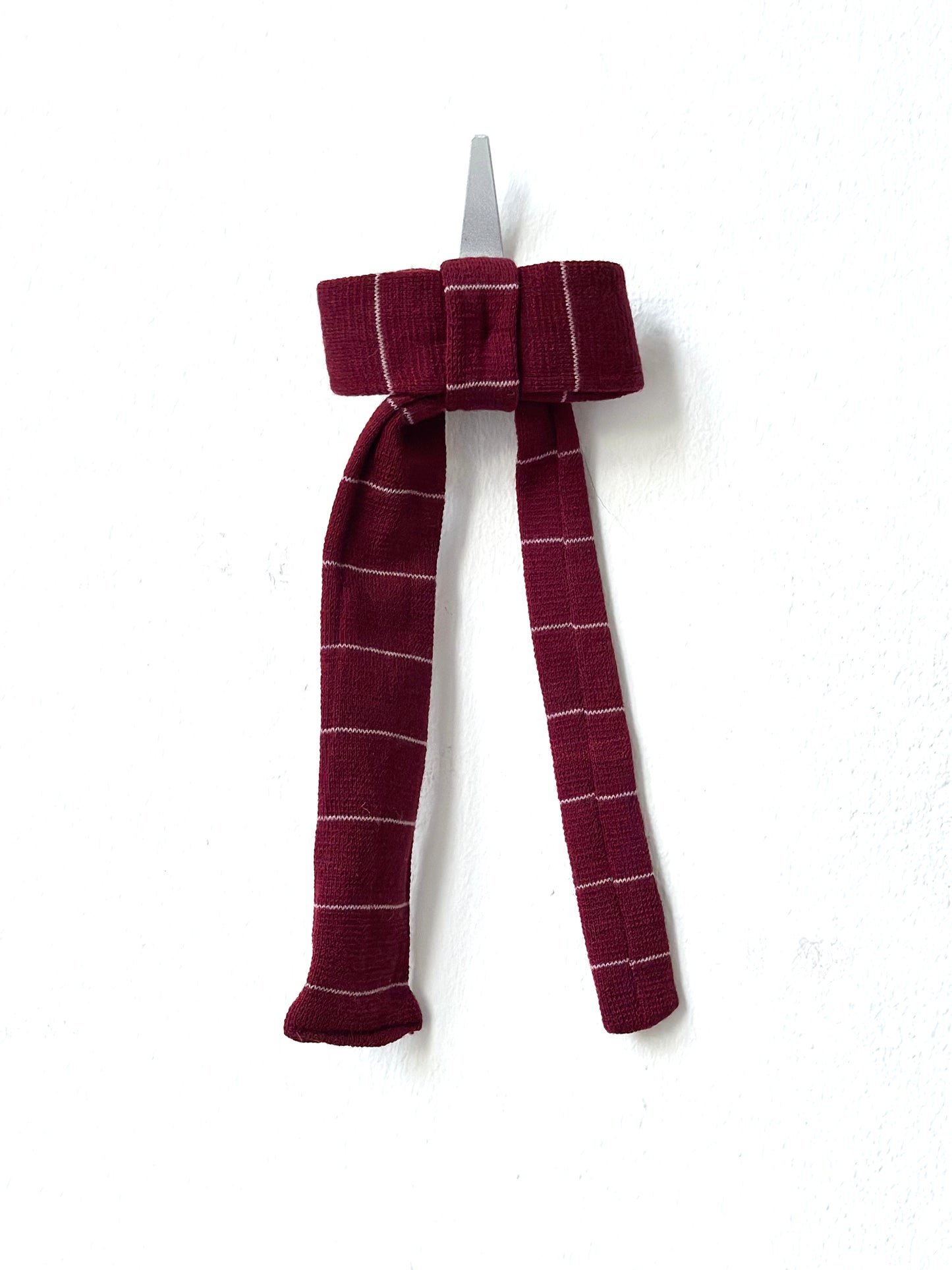 Maroon plaid bow hair clip on a white background