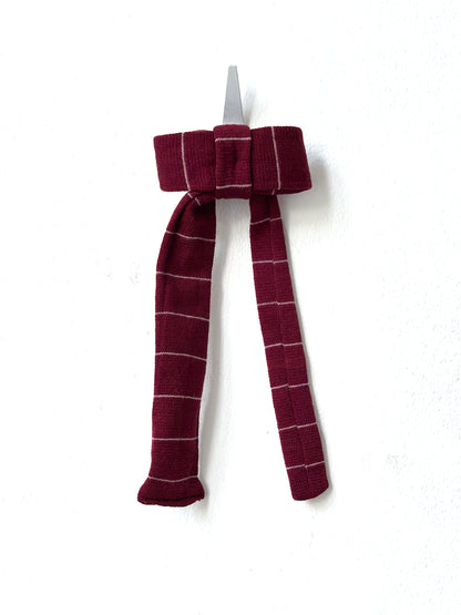 Maroon plaid bow hair clip on a white background