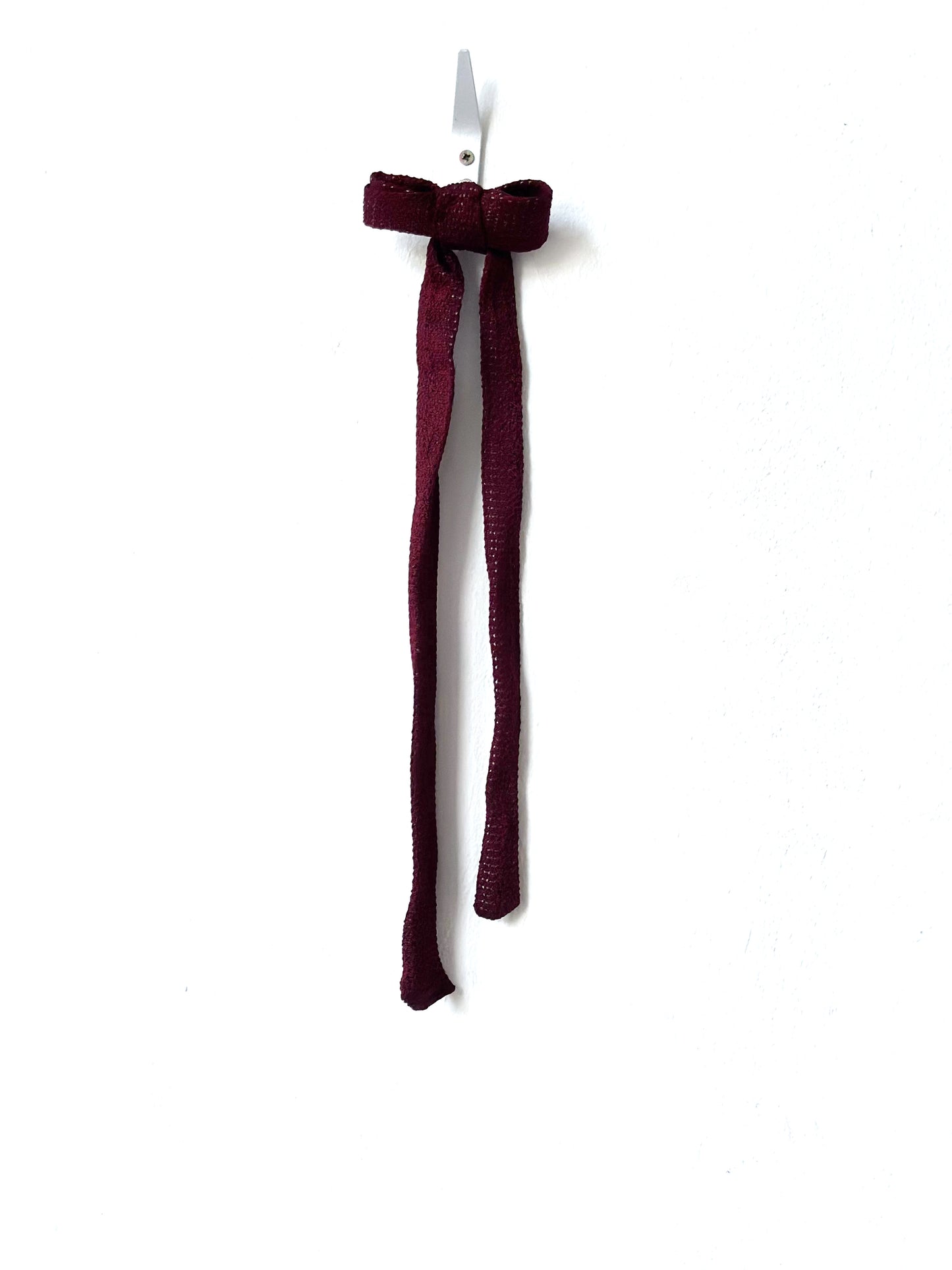 Burgundy knitted bow tie on a white background