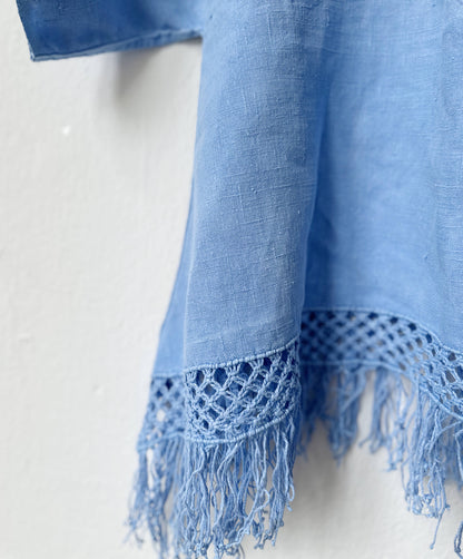 Blue top with fringes and textured edge on a white background