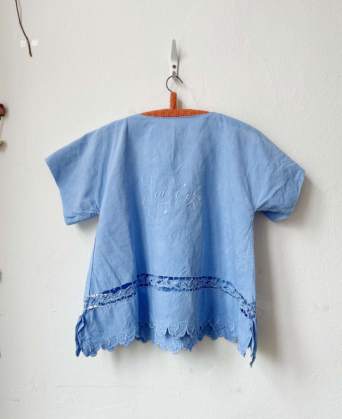 Light blue embroidered top on a white background