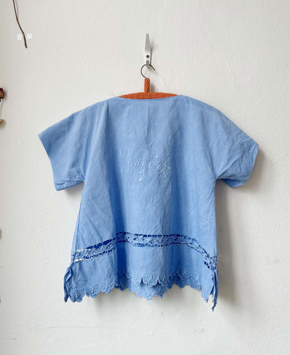 Light blue embroidered top on a white background