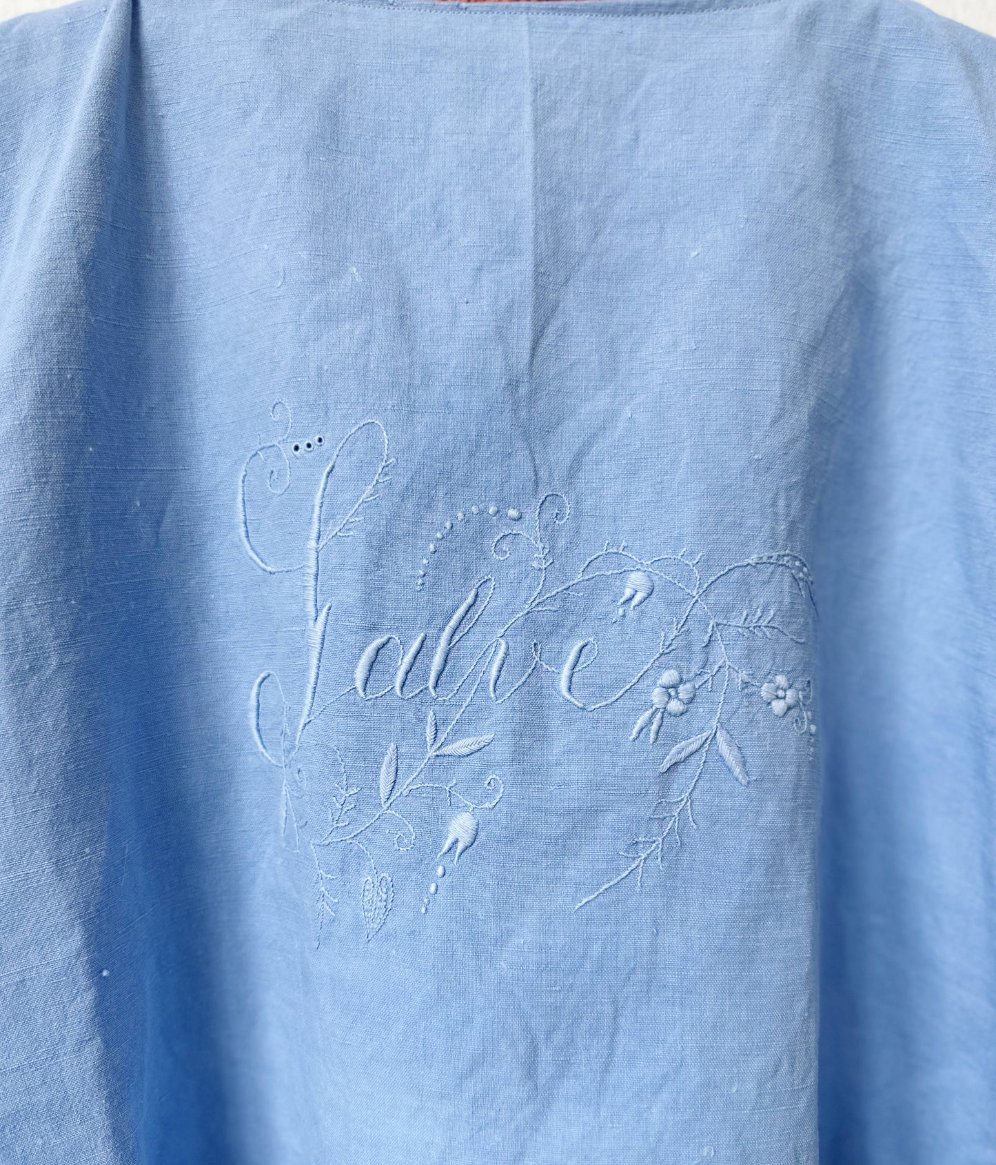 Light blue fabric with 'Salve' embroidered text and floral designs