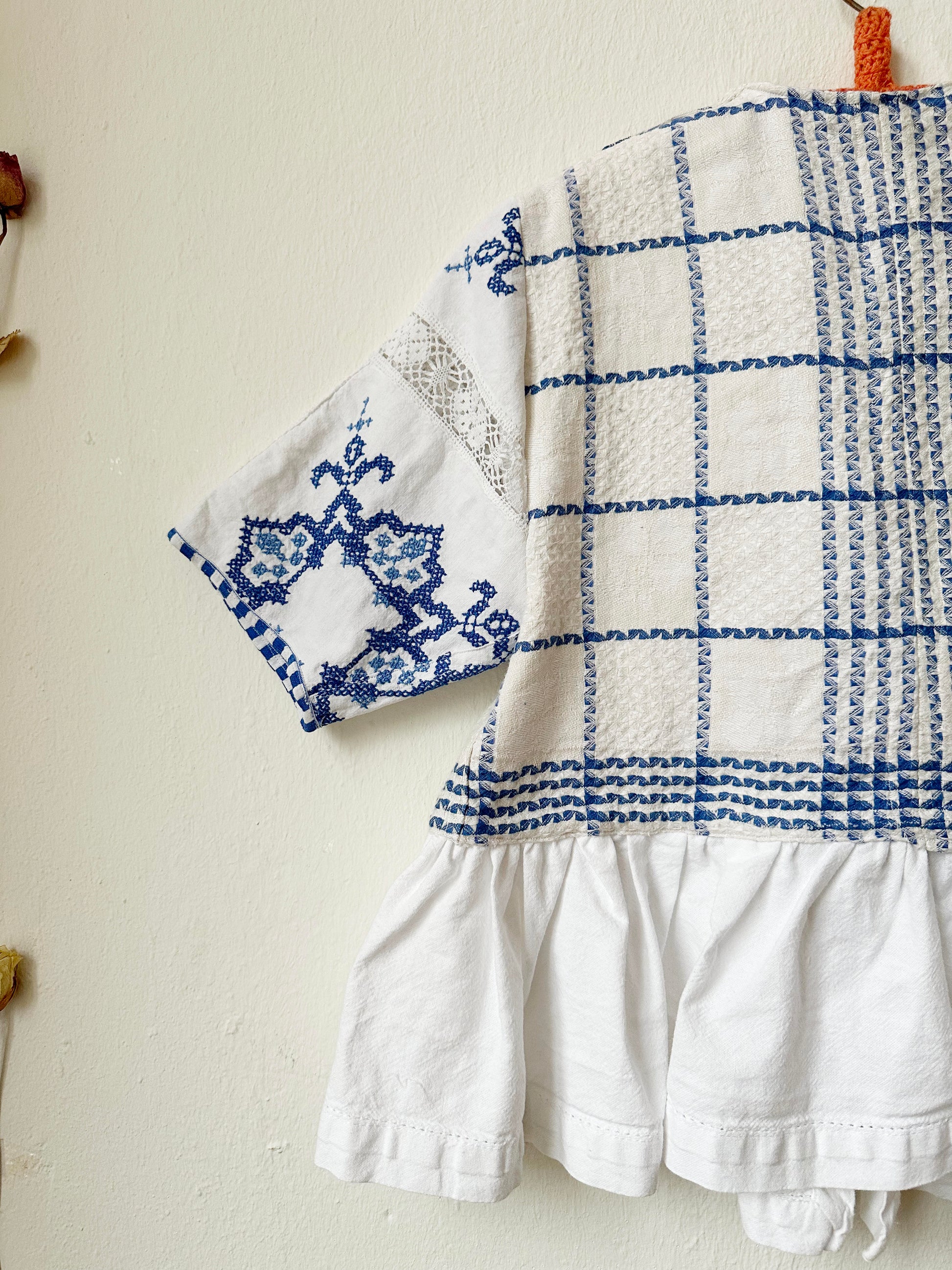 Detail view of blue and white check blouse sleeve 