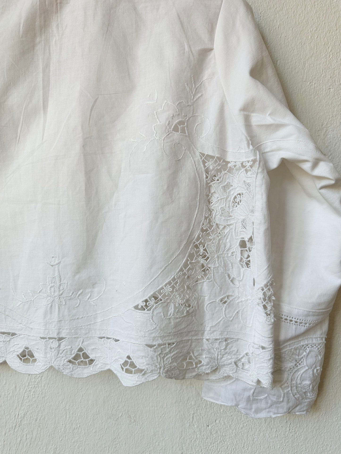 Detailed back view of white lace blouse. 