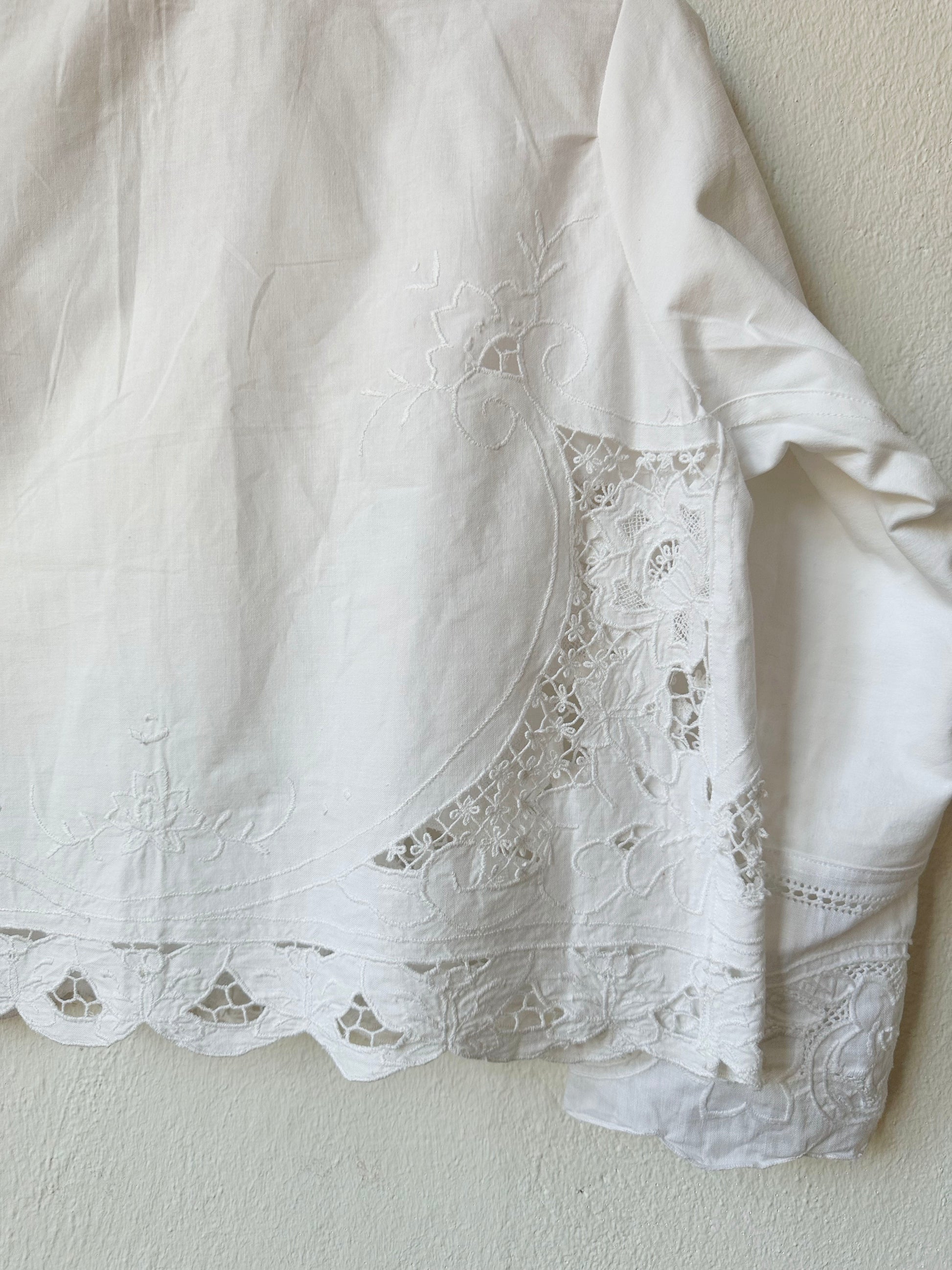Detailed back view of white lace blouse. 