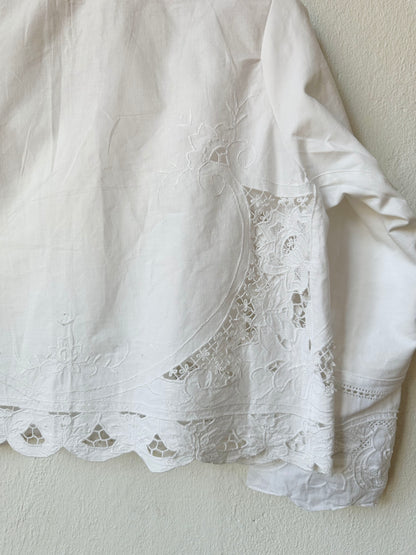 Detailed back view of white lace blouse. 