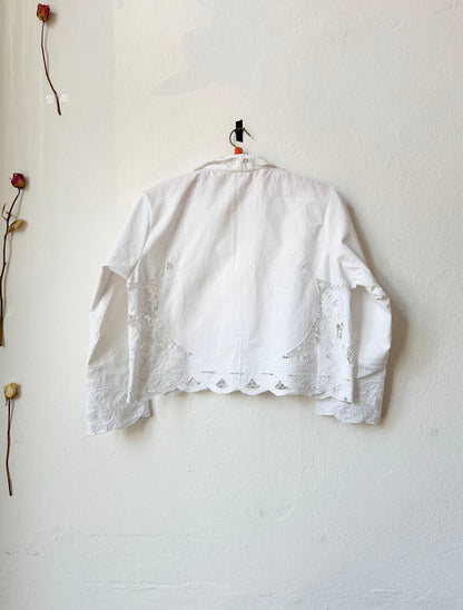 Back view of white lace blouse hanging on the wall. 