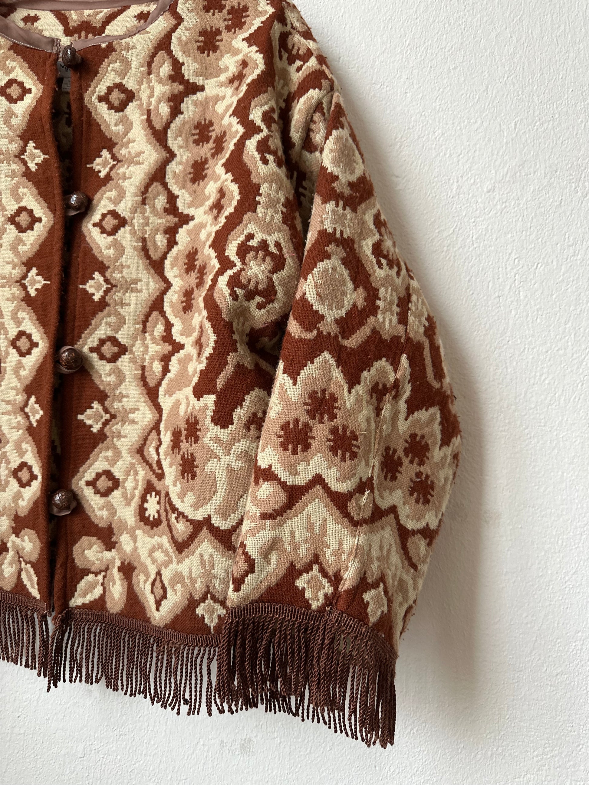 Brown and beige patterned fabric with fringes on a white background