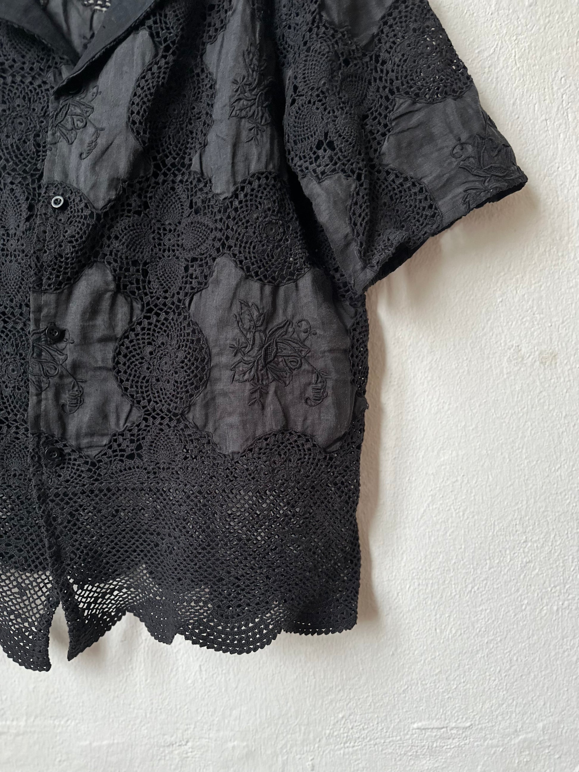 Black lace shirt on a white background.