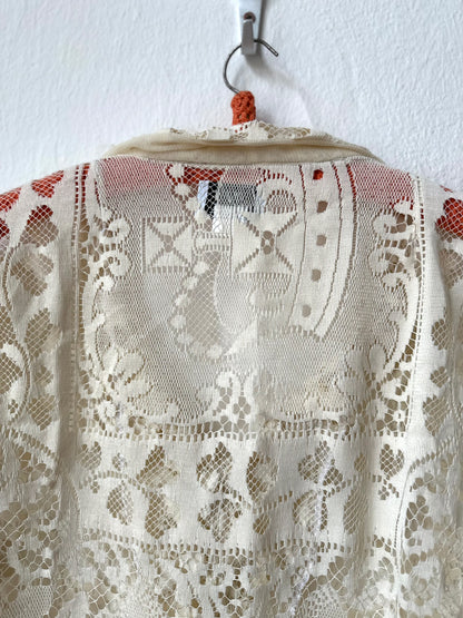 Lace shirt on a hanger against a white background