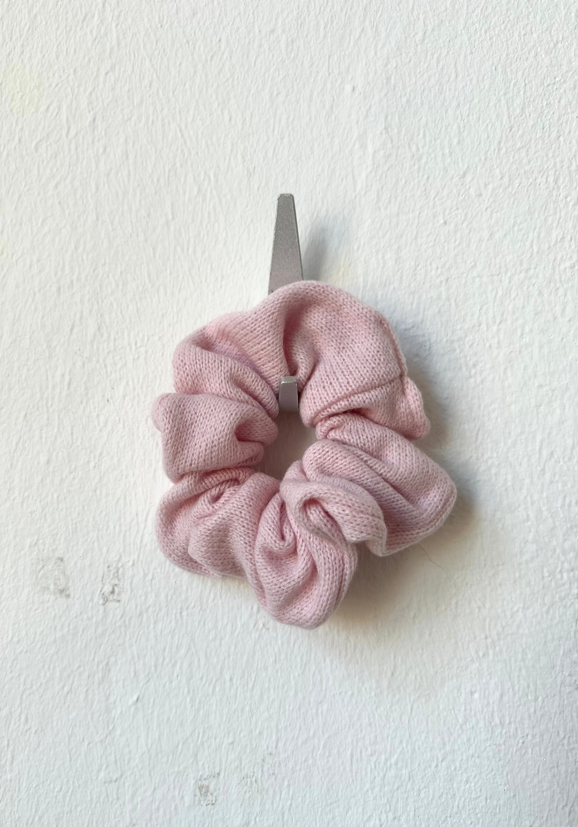 Pink knitted scrunchie on a white background