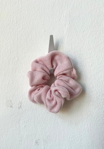 Pink knitted scrunchie on a white background