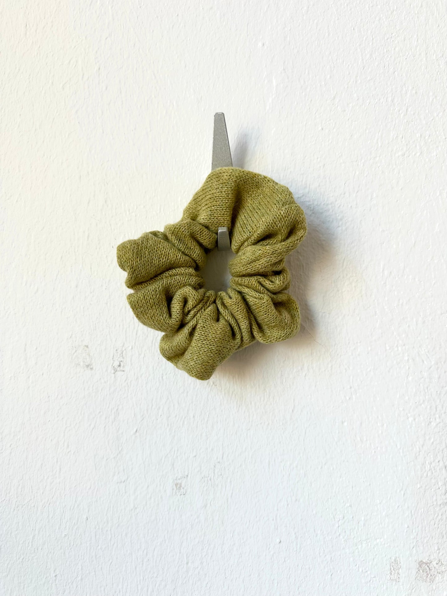 Green knitted scrunchie on a white background