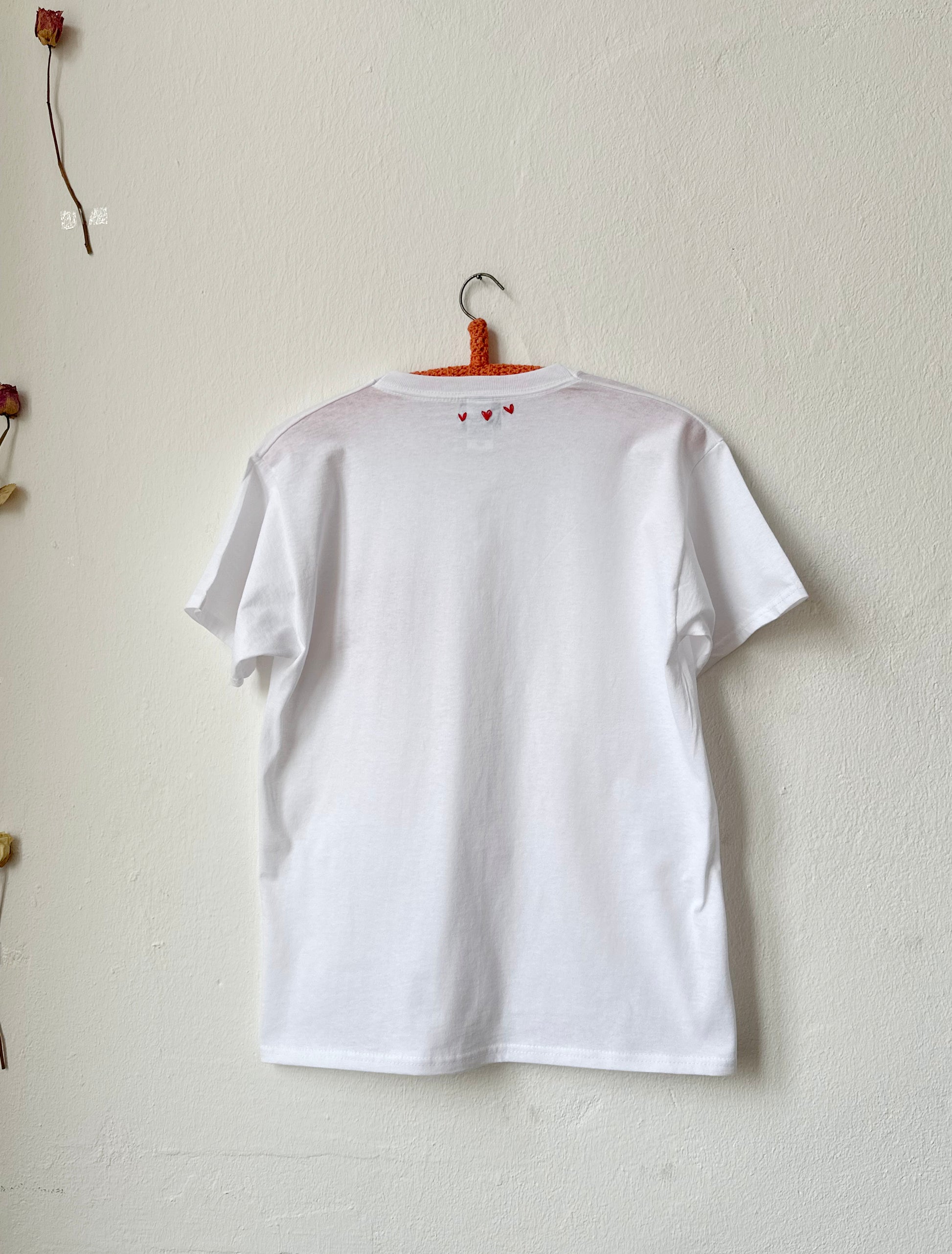 Back view of simple white tee featuring hand embroidered 'Meine Liebe' design, 100% cotton, classic silhouette.