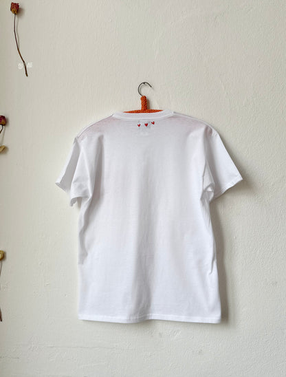 Back view of simple white tee featuring hand embroidered 'Meine Liebe' design, 100% cotton, classic silhouette.
