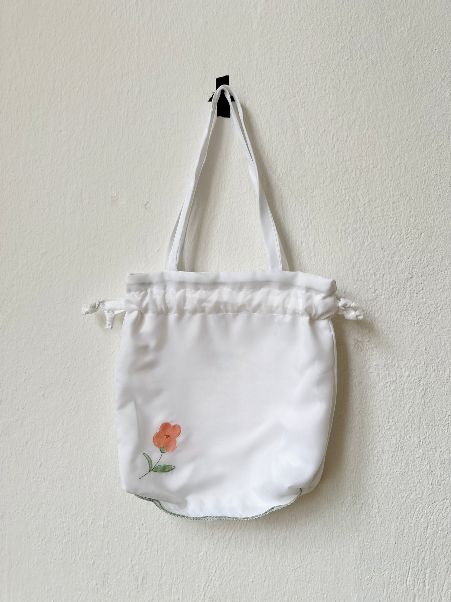 A close up view of the mini white tote bag with floral design