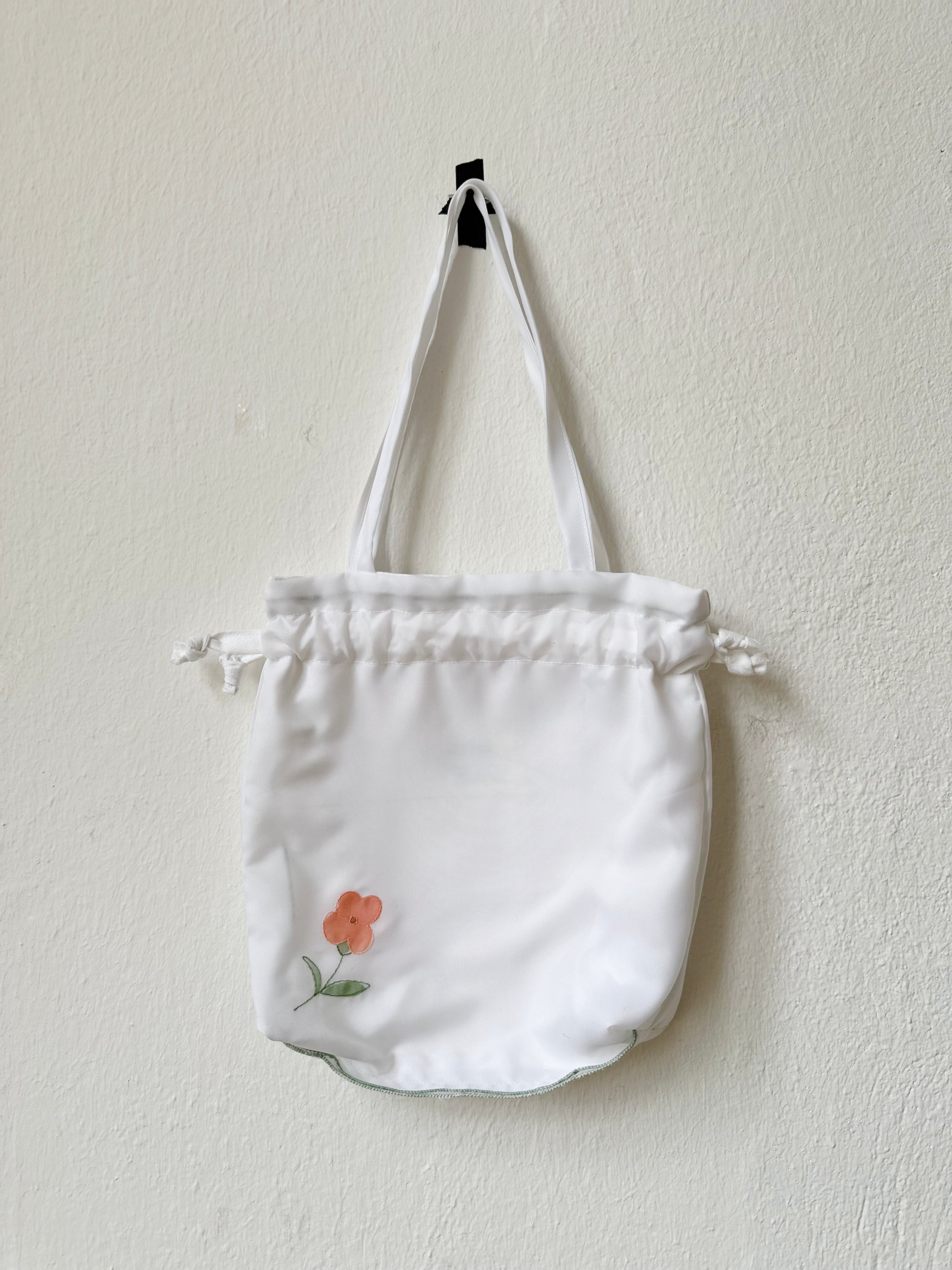 A close up view of the mini white tote bag with floral design