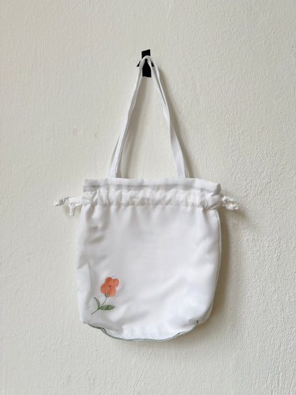 A close up view of the mini white tote bag with floral design