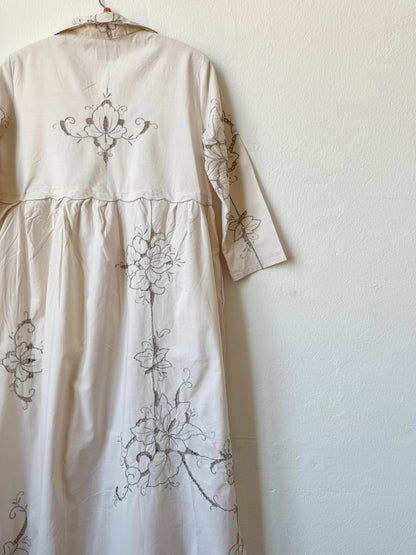 A detailed back view of a maxi length grey embroidered dress.