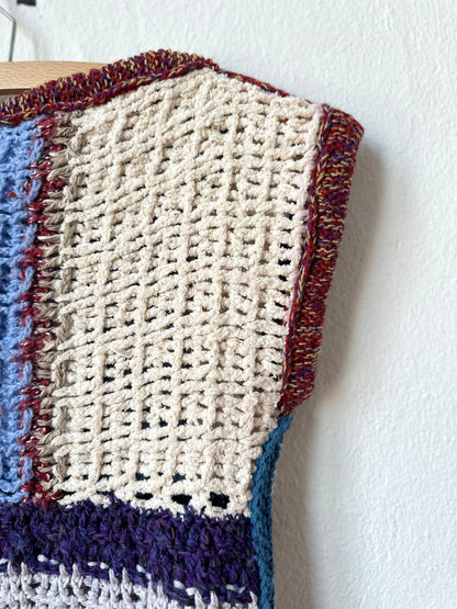 Detail view of a blanket vest armhole hanging on a wall.